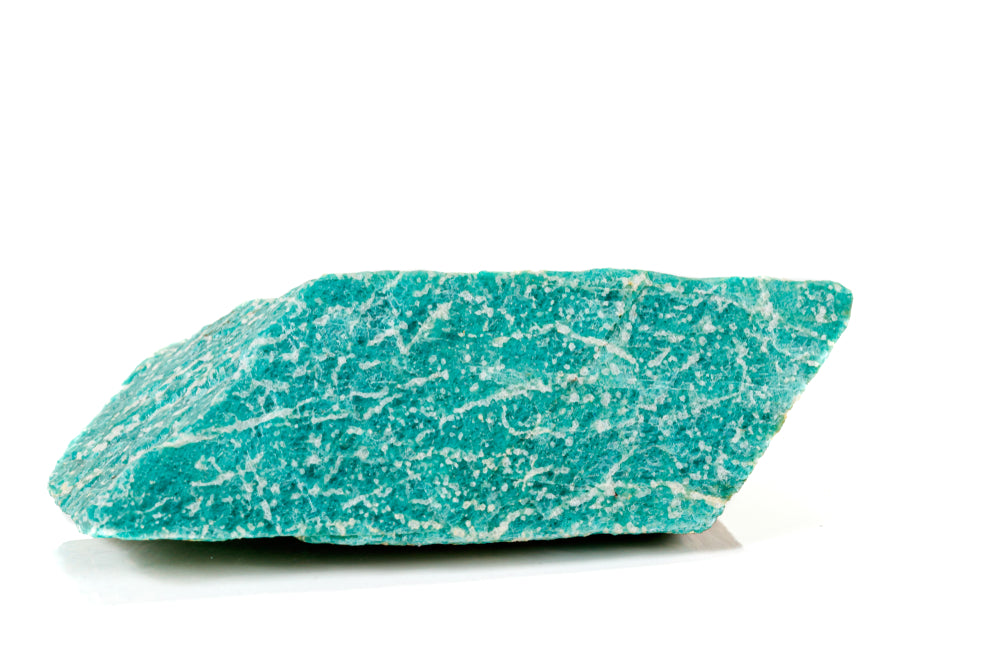Close up of a raw amazonite stone on a white background.